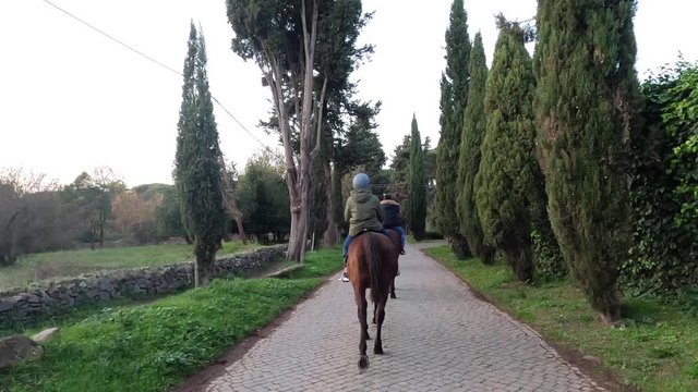 People on a touristic horseback ride on the Appian way in Rome. 4k