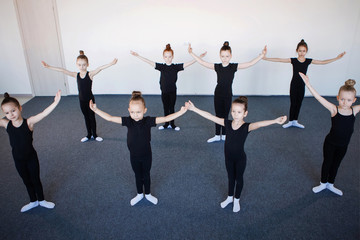 Girls in black leotards posing in dance.