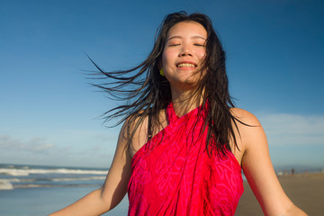 young sweet and happy Asian Korean woman in sarong at beautiful beach walking by the sea relaxed and blissful enjoying Summer holiday travel feeling free in Asia travel destination