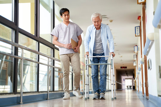 asian old man walking with a walker in rehab center