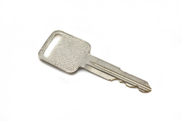 A silver car key, close up, isolated on a clean, white background.  Shot in macro.