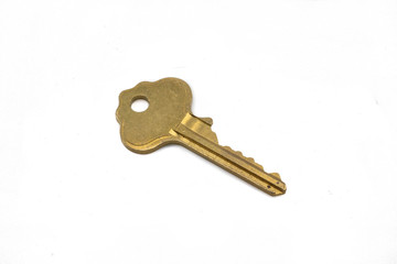 A gold house key, close up, isolated on a clean, white background.  Shot in macro.