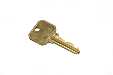 A brass security door key, close up, isolated on a clean, white background.  Shot in macro.