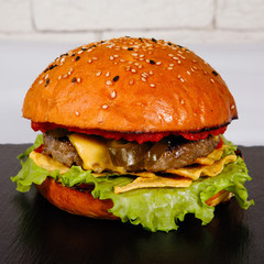 Tasty Burger on a plate in cafe.