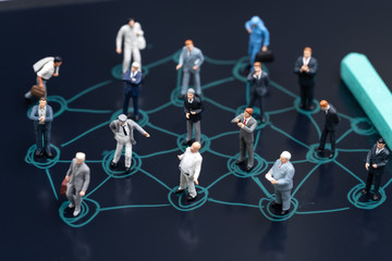 Social network, business connection network, teamwork or new connecting business concept, miniature people businessmen standing on connecting dot drawing with chalk on black chalkboard