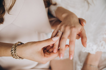 girls in white dresses with jewelry on hands holding hands