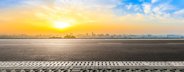 Empty asphalt road and city skyline at sunrise in Hangzhou,China.