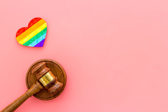 LGBT divorce. Rainbow heart near judge gavel on pink background top-down copy space © 9dreamstudio