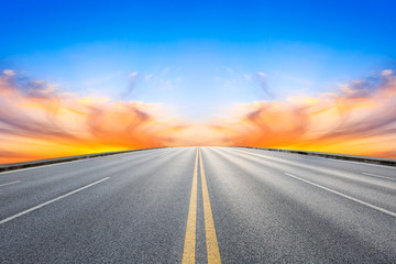 Fototapeta na wymiar Empty asphalt road and beautiful colorful clouds landscape at sunset.