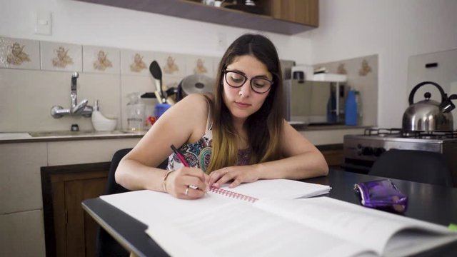 Hispanic girl studying in the kitchen