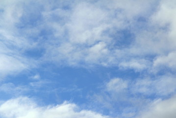 Cloudy blue sky with white and gray clouds. Background for text and design