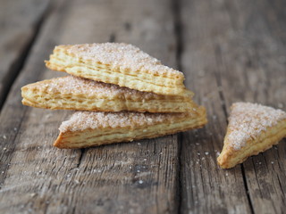 Homemade shortbread puff pastry Triangle on a wooden ancient rustic background. Side view. Place for text.