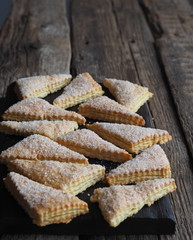 Homemade shortbread puff pastry Triangle on a wooden ancient rustic background. Side view. Place for text.