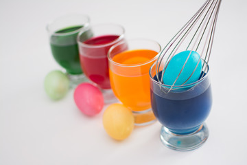 Easter eggs. Coloring eggs with colored liquid dyes in a glass goblet.