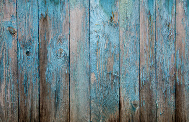 Battered faded old light blue painted vertical wooden boards with peeling. Wooden abstract background, texture.