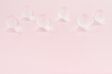 Abstract cosmetic background -  glass nucleuses on pastel pink backdrop, copy space.