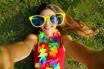 Girl take self portrait after Carnival party. Selfie young woman with big funny sunglasses and...