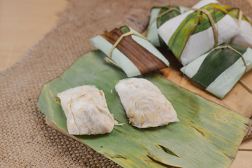 Tempe: raw tempeh (uncooked soybean cake) on banana leaf .