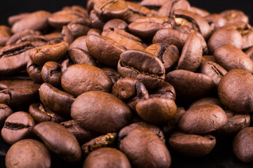 close-up texture and background of brown roasted aromatic coffee on a black background