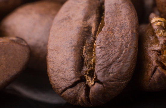 macro texture and background of brown roasted aromatic coffee on a black background