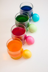 Easter eggs. Coloring eggs with colored liquid dyes in a glass goblet.