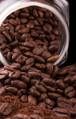 close-up of roasted coffee beans and ground coffee that fell out of the jar on the table
