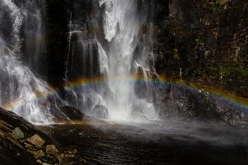 Fototapeta na wymiar Skjervsfossen Waterfall with a rainbow in Norway. Travel destination.