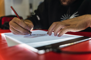  tattoo artist tracing a design on a light table