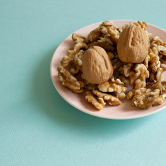 Walnuts on dish with mint green background