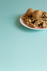 Walnuts on dish with mint green background