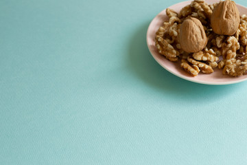 Walnuts on dish with mint green background