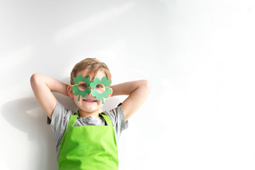 St Patrick's Day holiday concept. Joyful caucasian boy with green paper leprechaun hat with clover...