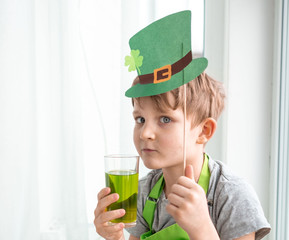 St Patrick's Day holiday concept. Joyful emotional caucasian boy with green paper leprechaun hat...