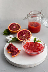 Homemade blood orange jam. Natural, healthy food. Side view, gray background, copy space.