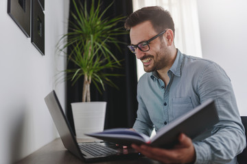 Handsome man using laptop computer at home,