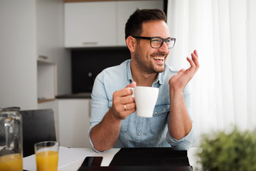 Handsome man having cup of coffee at home in the morning
