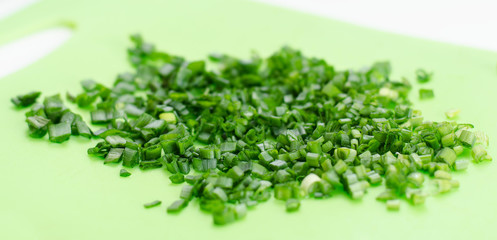 Obraz premium Chopped green onion lies on a blackboard