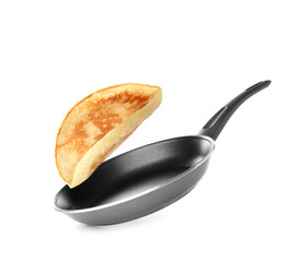Frying pan and tasty falling pancake on white background