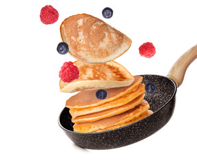 Frying pan with flying pancakes on white background