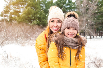 Mother with little daughter in park on winter day