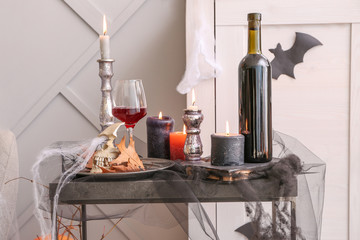 Decor for Halloween party with wine on table in room