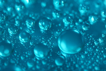 Many water drops on blue background, closeup