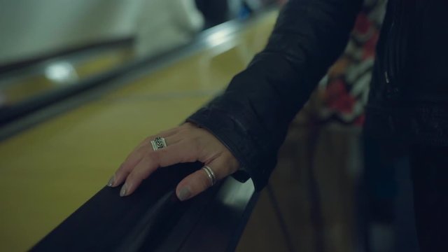 Woman riding down on a subway escalator