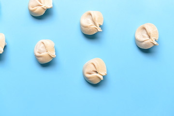Raw fresh dumplings on color background