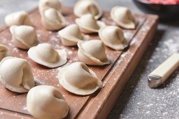 Fototapeta na wymiar Raw fresh dumplings on wooden board