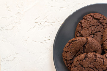 Top view, chocolate chip cookies on a black plate. white concrete background. From above. copy space