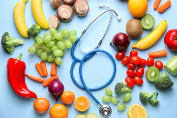 Healthy products and stethoscope on color background