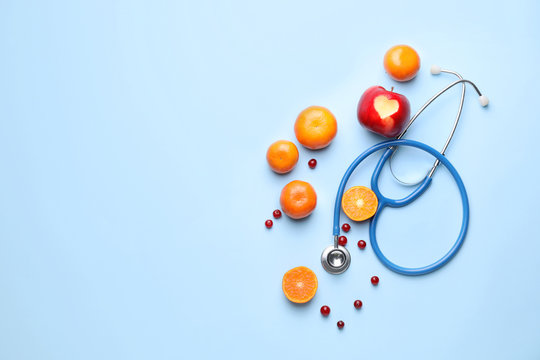 Healthy products and stethoscope on color background