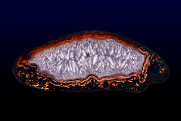Fototapeta premium Polished slice of Agate and Quartz, isolated on a dark background. 