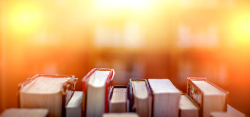 Stack of books in the library and blur bookshelf background